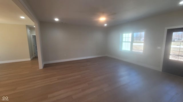 empty room with plenty of natural light, baseboards, and light wood-style floors