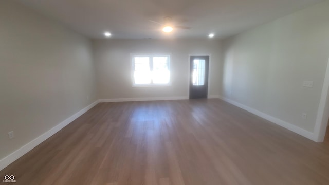 empty room featuring recessed lighting, baseboards, and wood finished floors