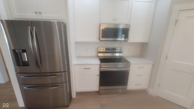 kitchen with white cabinetry, light countertops, and stainless steel appliances