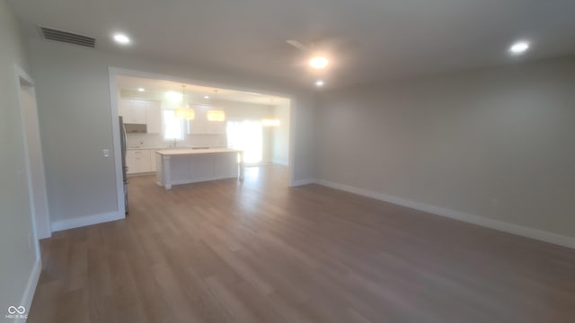 unfurnished living room featuring recessed lighting, visible vents, baseboards, and light wood finished floors