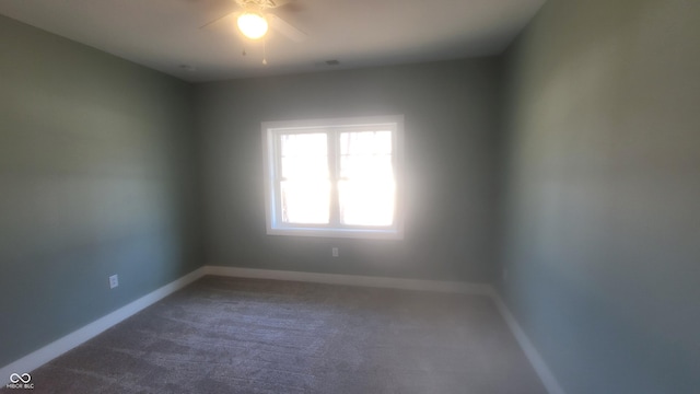 unfurnished room featuring a ceiling fan, baseboards, and dark carpet