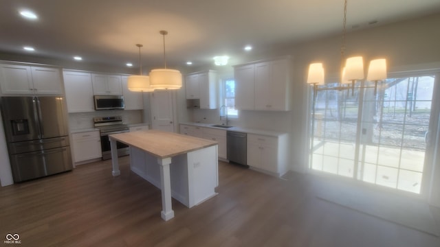 kitchen with wood finished floors, a sink, light countertops, white cabinets, and appliances with stainless steel finishes