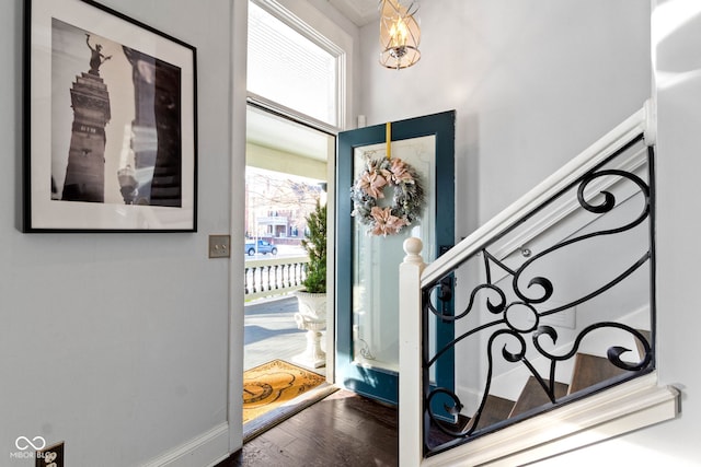 foyer featuring stairs, baseboards, and wood finished floors