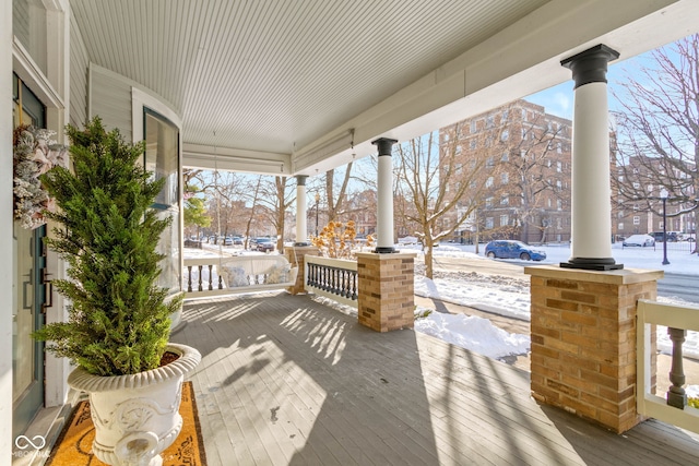 snow covered patio featuring covered porch