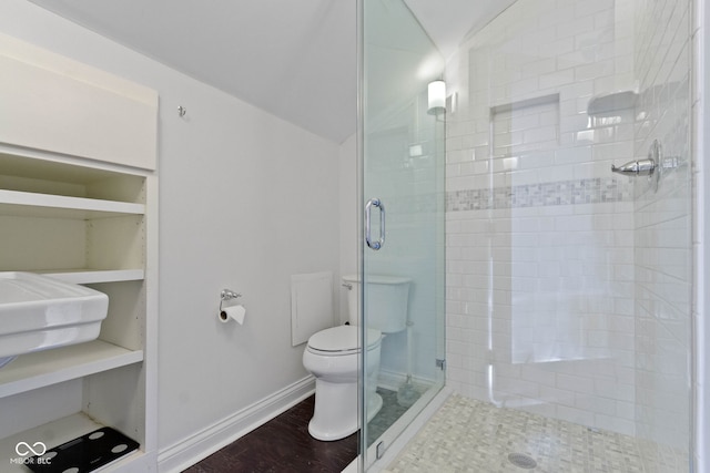 bathroom with toilet, a stall shower, vaulted ceiling, wood finished floors, and baseboards