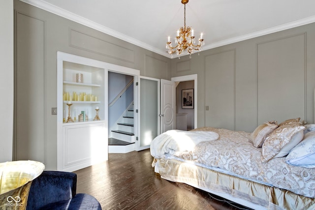 bedroom with a chandelier, a decorative wall, crown molding, and wood finished floors