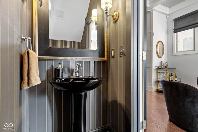 bathroom featuring ornamental molding, visible vents, a sink, and wood finished floors