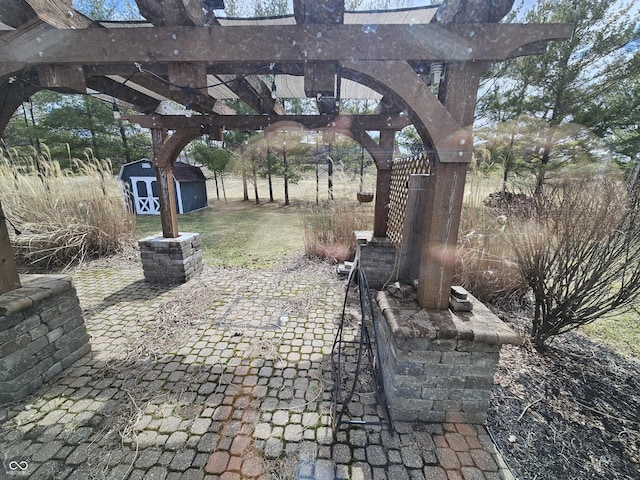 view of patio / terrace with a storage shed, a pergola, and an outbuilding