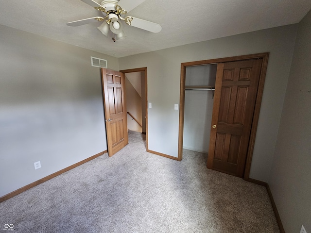 unfurnished bedroom featuring baseboards, visible vents, light colored carpet, ceiling fan, and a closet