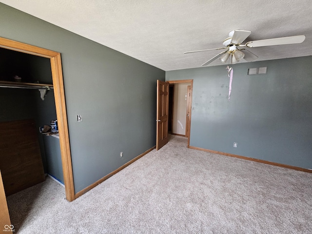 unfurnished bedroom with a closet, a spacious closet, baseboards, and a textured ceiling