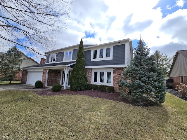 traditional home with a garage, driveway, a front yard, and brick siding