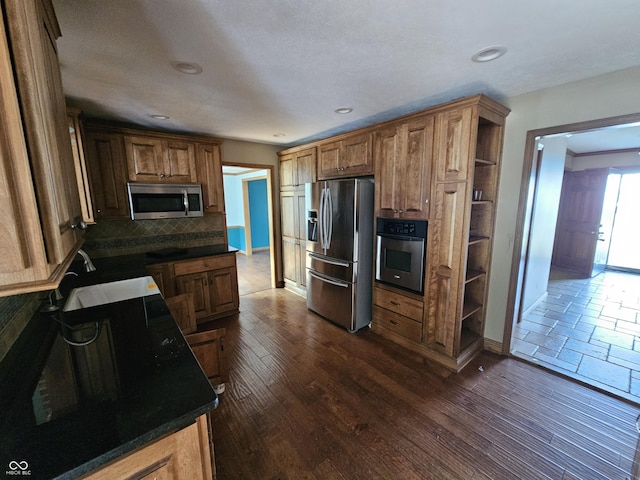 kitchen featuring open shelves, stainless steel appliances, dark countertops, backsplash, and dark wood-type flooring