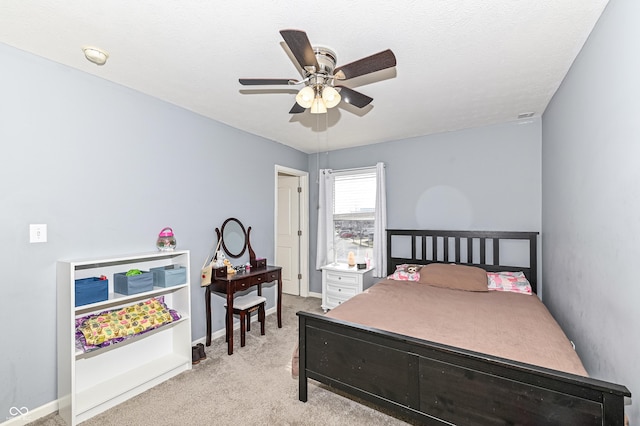 bedroom featuring ceiling fan, baseboards, a textured ceiling, and light colored carpet