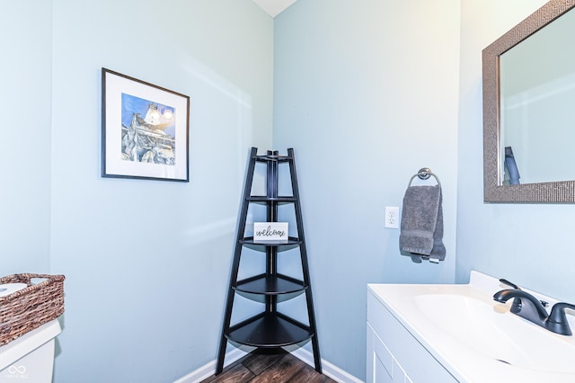 bathroom featuring wood finished floors, vanity, and baseboards