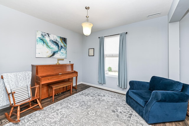 sitting room featuring wood finished floors, visible vents, and baseboards