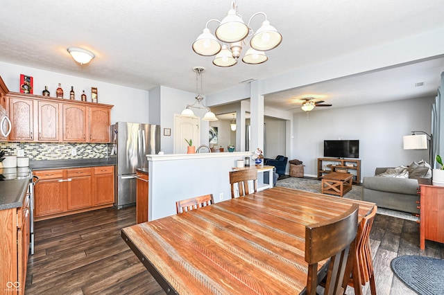 dining area featuring dark wood-style floors, visible vents, and ceiling fan with notable chandelier