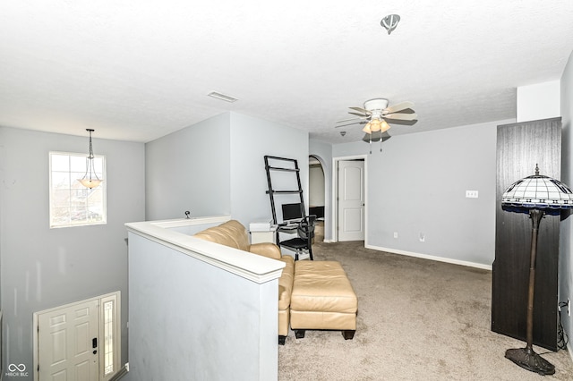 living room with carpet, visible vents, ceiling fan, a textured ceiling, and baseboards