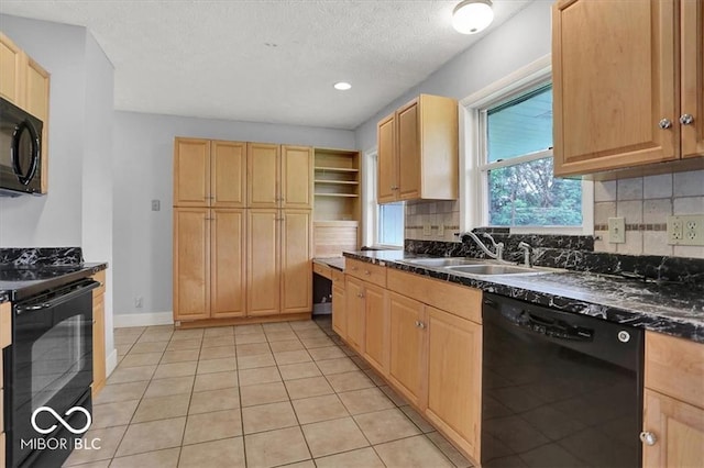 kitchen with a sink, backsplash, black appliances, and light brown cabinetry