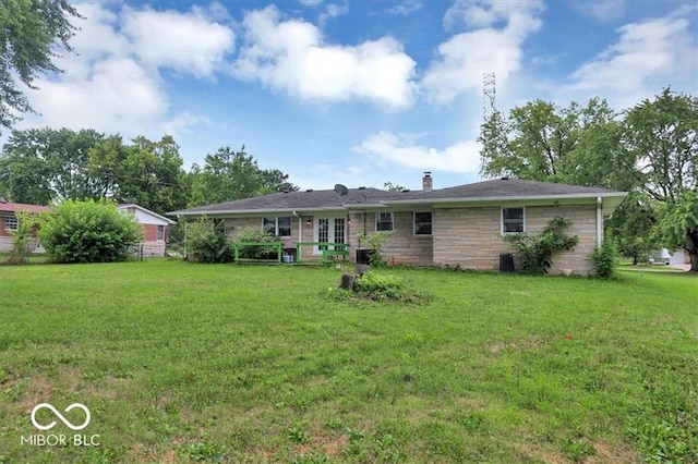 ranch-style home with french doors, a chimney, and a front lawn