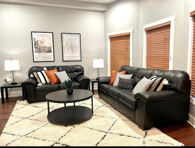 living area featuring dark wood-style flooring and baseboards