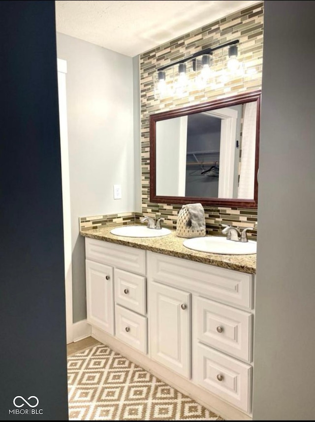 bathroom with double vanity, tasteful backsplash, and a sink