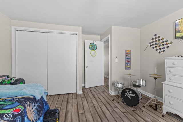 bedroom featuring a closet, baseboards, and wood finished floors