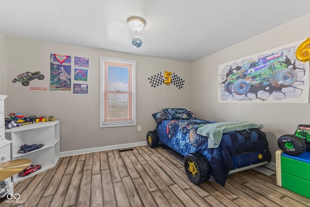 bedroom featuring wood finished floors and baseboards