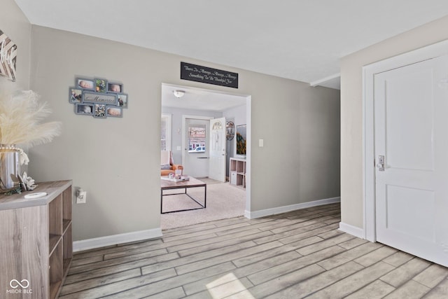 corridor with wood finished floors and baseboards