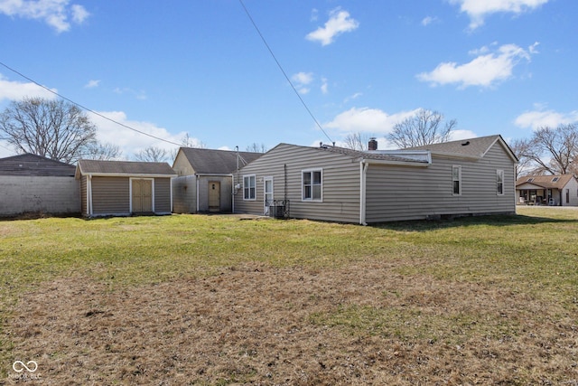 rear view of house with a yard, an outdoor structure, a chimney, and a storage unit