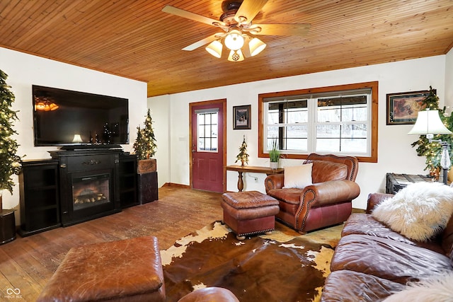 living area with wooden ceiling, a glass covered fireplace, hardwood / wood-style flooring, and a ceiling fan