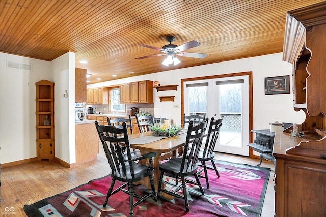 dining space featuring light wood finished floors, baseboards, visible vents, wooden ceiling, and french doors