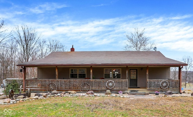 farmhouse featuring a porch and a chimney