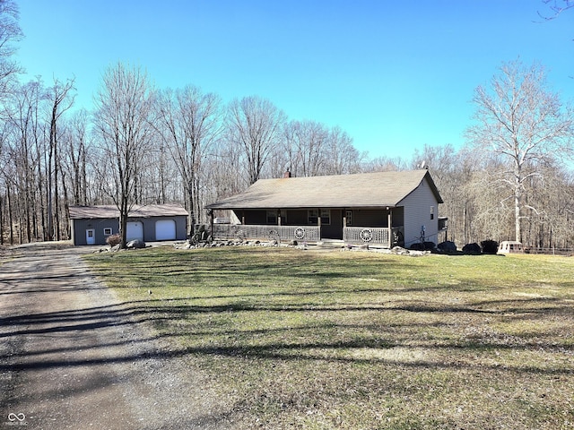 view of front of home featuring an outbuilding, a chimney, covered porch, a garage, and a front lawn