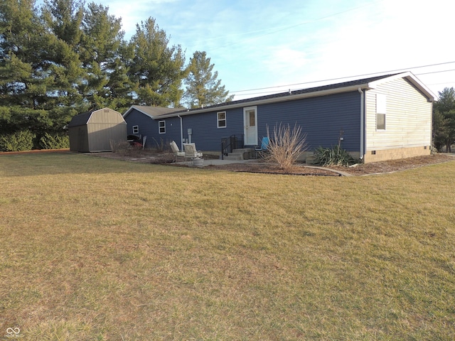 back of property featuring a yard, entry steps, an outdoor structure, a storage unit, and crawl space