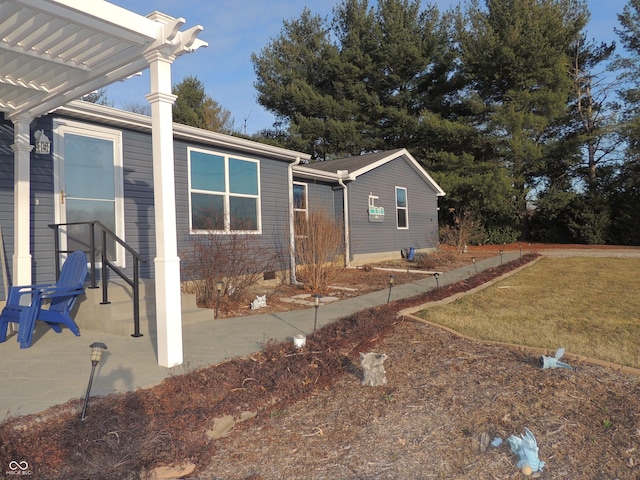 view of front facade with a front yard, a pergola, and crawl space