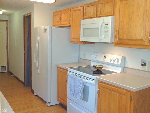 kitchen featuring white appliances, baseboards, light countertops, light wood-style floors, and a textured ceiling