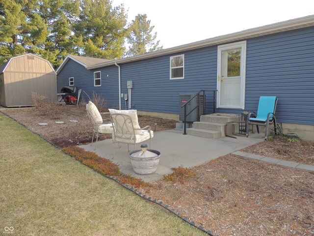 back of property featuring a shed, entry steps, a lawn, an outdoor structure, and a patio area