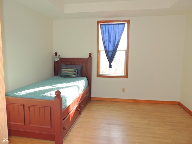 unfurnished bedroom with baseboards and light wood-style flooring