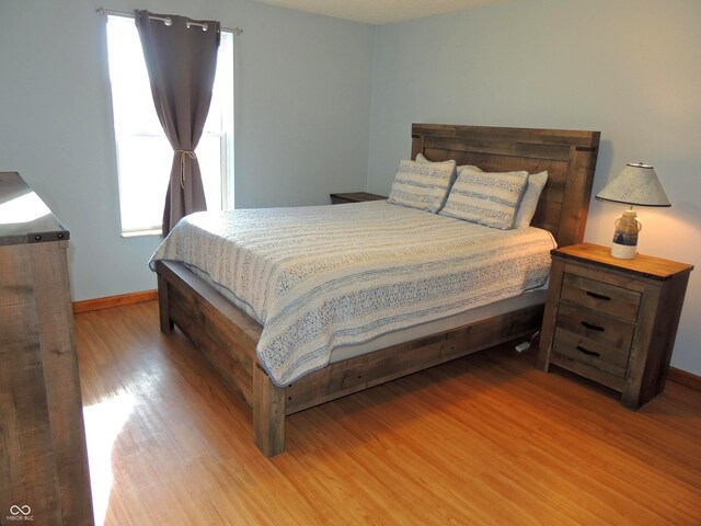 bedroom with wood finished floors and baseboards