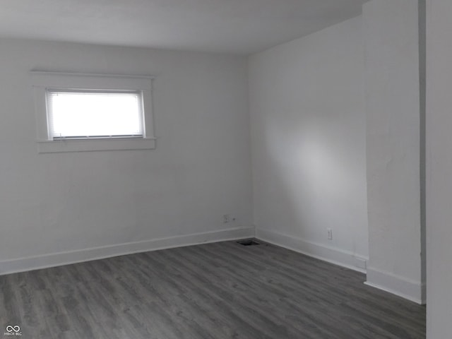 unfurnished room with dark wood-style floors and baseboards