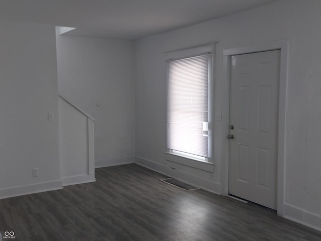 entrance foyer featuring baseboards, visible vents, and dark wood-type flooring