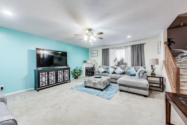 carpeted living room featuring stairway, a fireplace, a ceiling fan, and baseboards