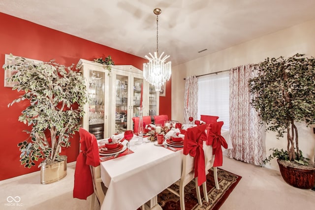 carpeted dining room with a chandelier