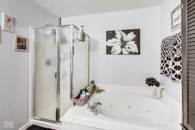 bathroom with a jetted tub, a stall shower, and a textured ceiling