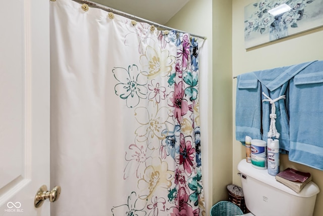 full bath featuring a shower with shower curtain and toilet