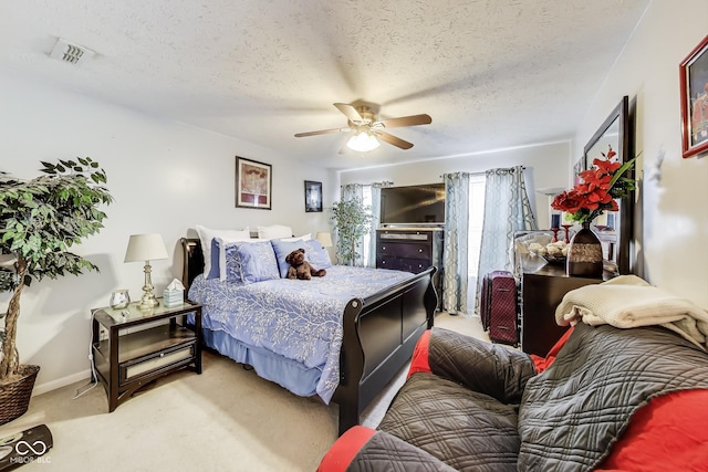 bedroom with visible vents, light colored carpet, ceiling fan, a textured ceiling, and baseboards