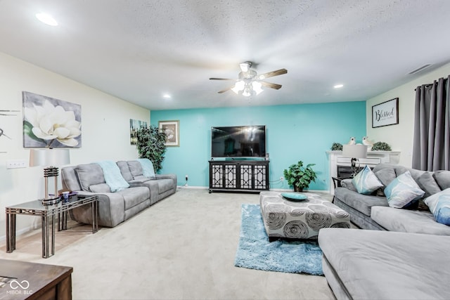 living room featuring visible vents, carpet flooring, ceiling fan, a textured ceiling, and baseboards