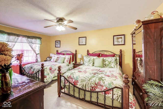 bedroom featuring a textured ceiling, carpet, and a ceiling fan