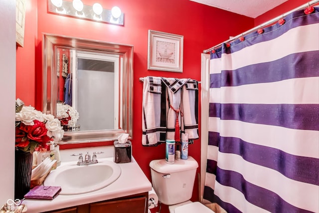 bathroom featuring toilet, vanity, and a shower with curtain