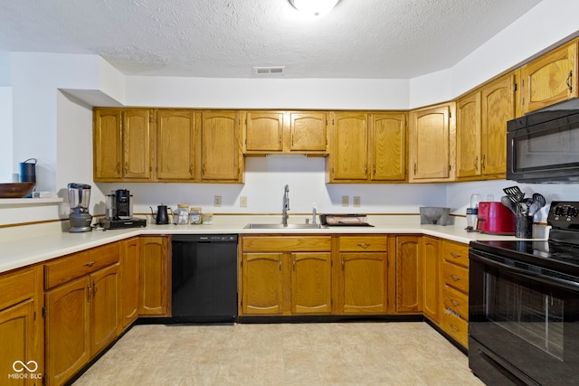 kitchen featuring brown cabinetry, light countertops, a sink, and black appliances